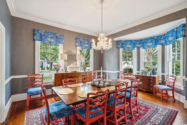 dining area featuring crown molding, wood-type flooring, and a chandelier