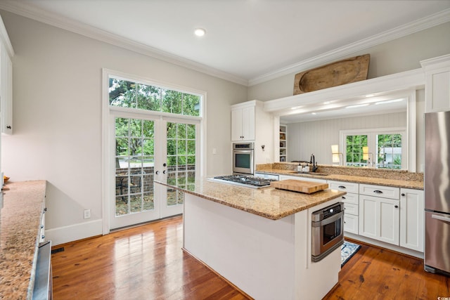 kitchen featuring appliances with stainless steel finishes, a kitchen island, and hardwood / wood-style floors