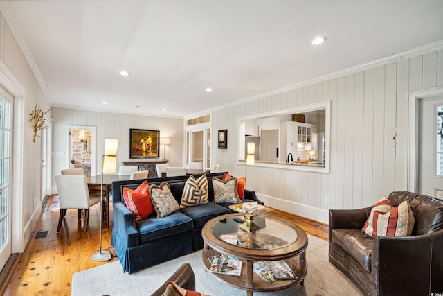 living room with light wood-type flooring and crown molding