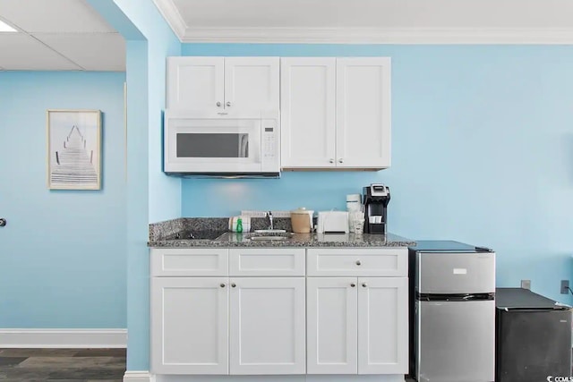 bar featuring hardwood / wood-style floors, crown molding, white cabinetry, and stainless steel fridge