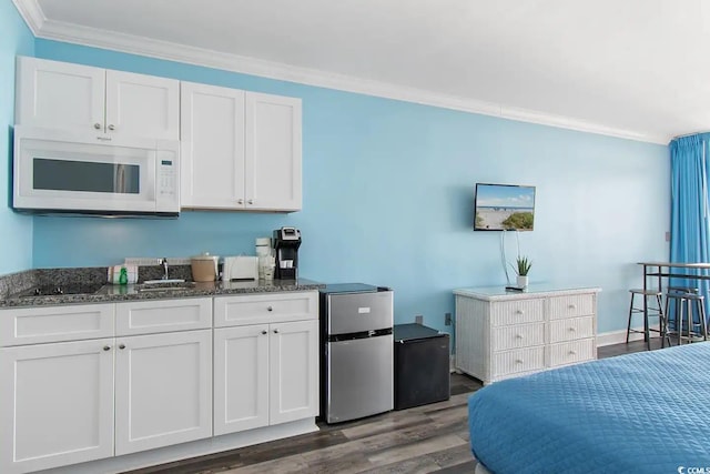 bedroom featuring hardwood / wood-style flooring, refrigerator, ornamental molding, and stainless steel refrigerator