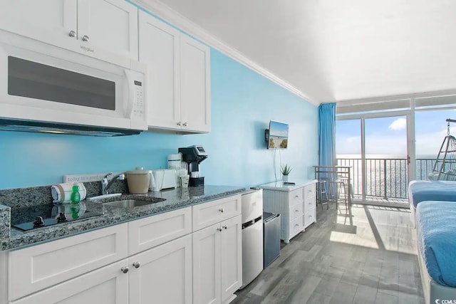 kitchen with sink, white cabinets, light wood-type flooring, and crown molding