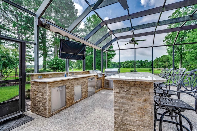 view of patio featuring sink, a lanai, grilling area, and an outdoor kitchen