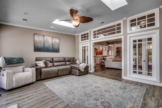 living room featuring ceiling fan, french doors, a skylight, and hardwood / wood-style flooring