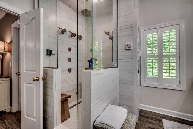 bathroom featuring hardwood / wood-style floors, a tile shower, and a healthy amount of sunlight