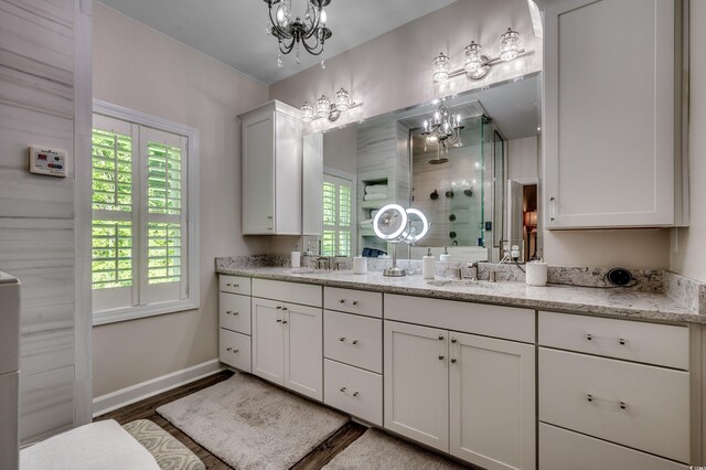 bathroom featuring a notable chandelier, double vanity, and hardwood / wood-style floors