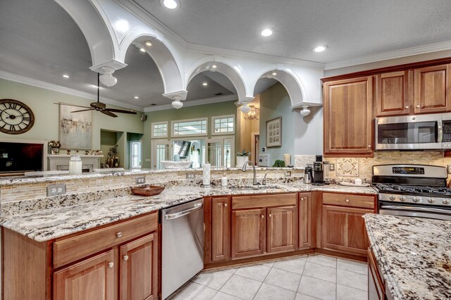 kitchen with decorative backsplash, appliances with stainless steel finishes, ceiling fan, sink, and light tile patterned flooring