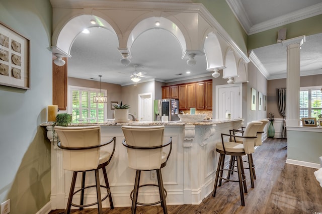 kitchen with dark hardwood / wood-style flooring, stainless steel refrigerator with ice dispenser, light stone countertops, ceiling fan, and backsplash