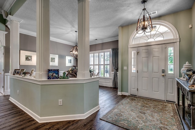 entrance foyer with dark wood-type flooring, decorative columns, a textured ceiling, and ornamental molding