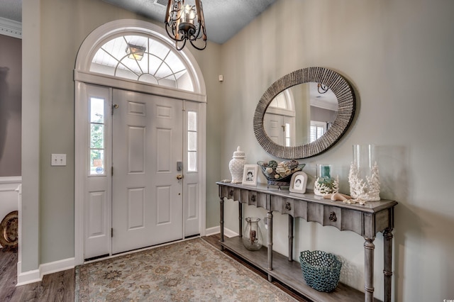 entrance foyer featuring hardwood / wood-style floors and a chandelier