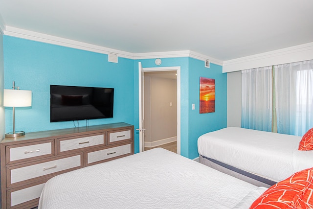 bedroom with hardwood / wood-style flooring and crown molding