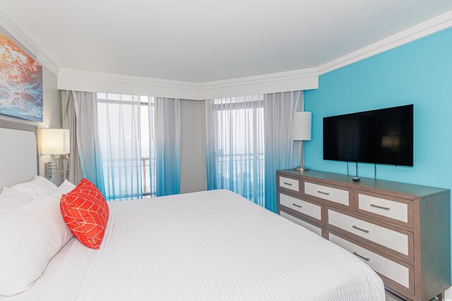 bedroom featuring multiple windows and crown molding