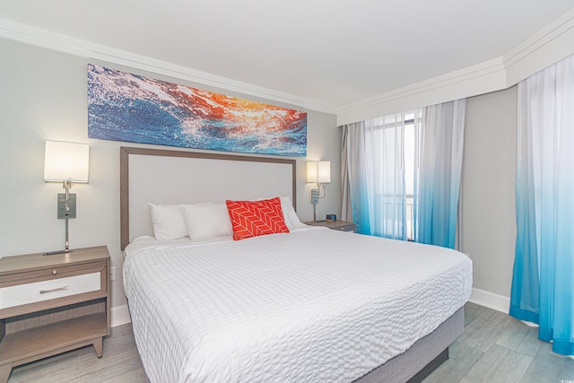 bedroom featuring light wood-type flooring and crown molding