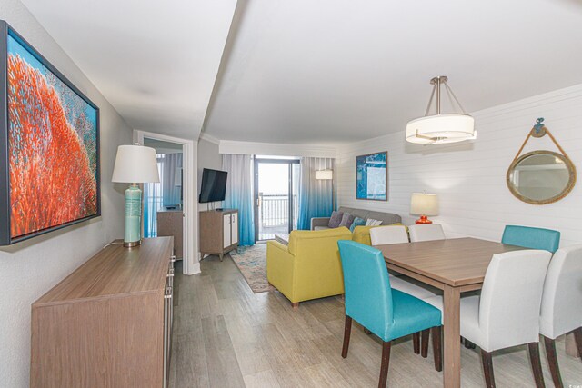 dining space with hardwood / wood-style floors and wood walls