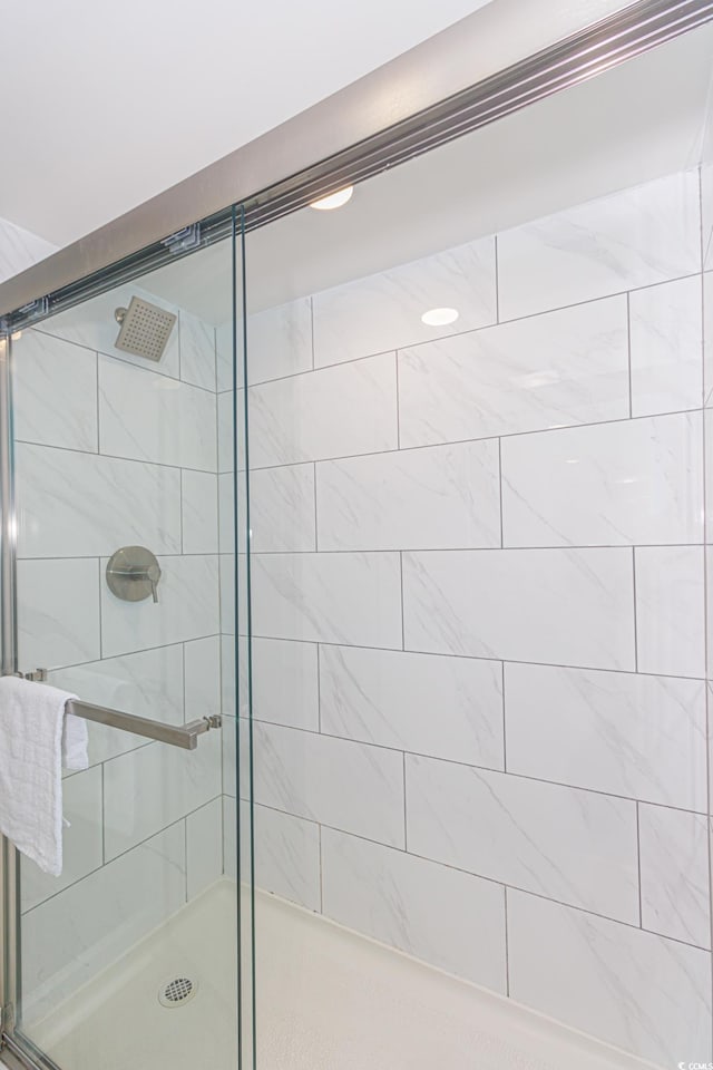 bathroom featuring a shower with door