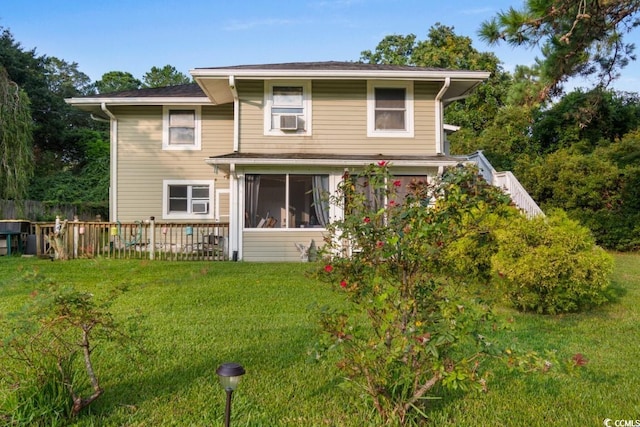 back of property featuring a sunroom, cooling unit, and a lawn