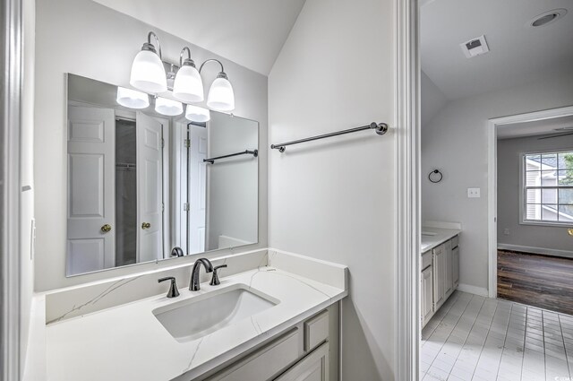 bathroom featuring vanity, hardwood / wood-style floors, and lofted ceiling