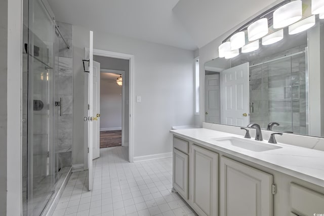 full bath with a shower stall, baseboards, tile patterned flooring, and vanity