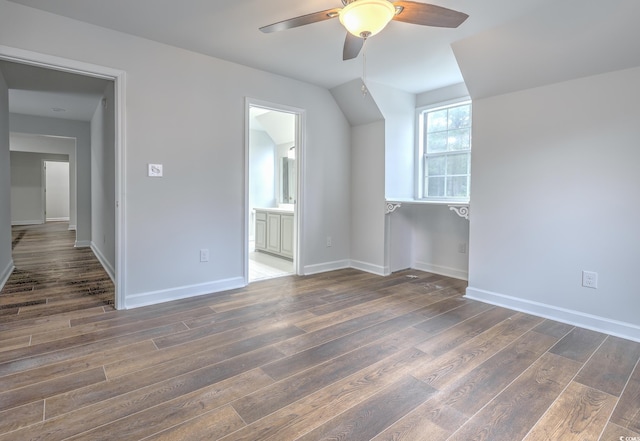 additional living space featuring baseboards, dark wood finished floors, and a ceiling fan