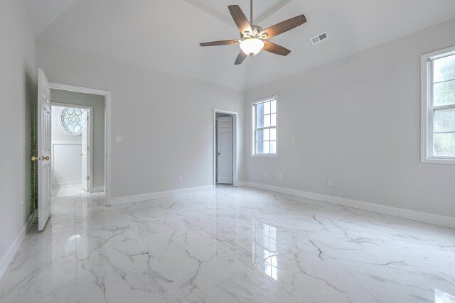 unfurnished room featuring ceiling fan, light tile patterned flooring, plenty of natural light, and lofted ceiling