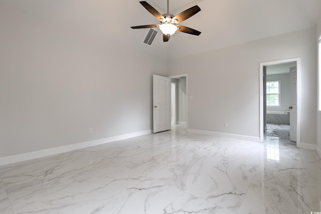 unfurnished bedroom featuring a towering ceiling, light tile patterned flooring, and ceiling fan