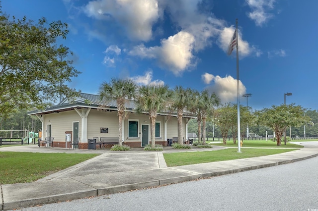 view of front of house with metal roof and a front lawn