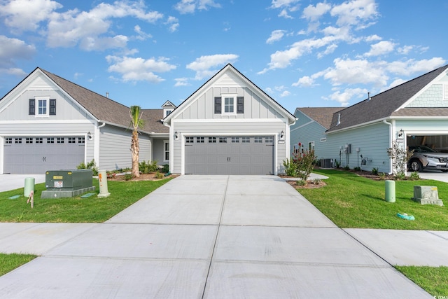 view of front of house featuring central AC, a front yard, and a garage