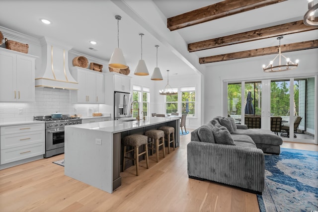 kitchen with stainless steel appliances, a chandelier, and white cabinets