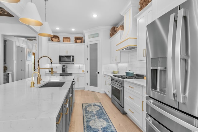 kitchen featuring stainless steel appliances, white cabinetry, sink, and pendant lighting