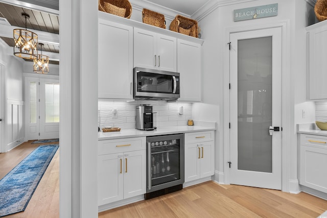 kitchen featuring wine cooler, backsplash, light hardwood / wood-style flooring, and white cabinets