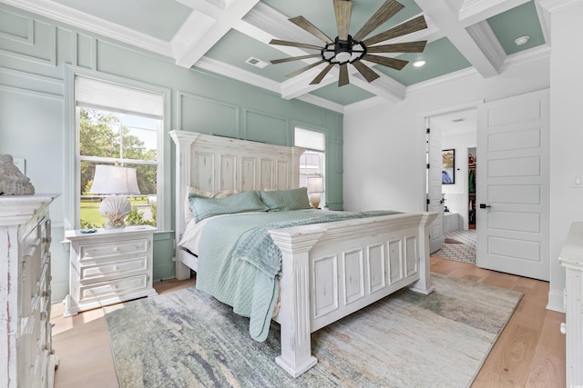 bedroom with beamed ceiling, crown molding, coffered ceiling, and light wood-type flooring