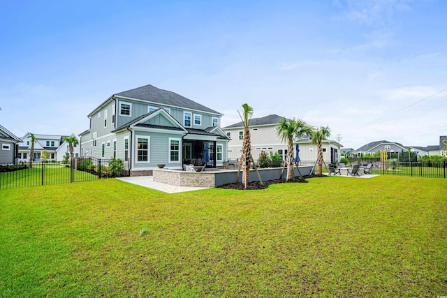 back of house with a lawn and a patio