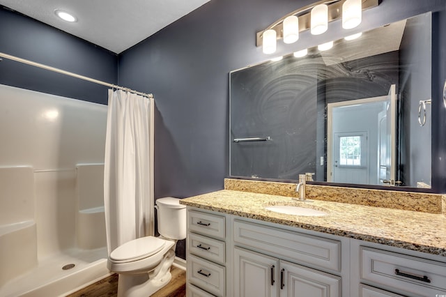 bathroom featuring vanity, walk in shower, hardwood / wood-style floors, and toilet