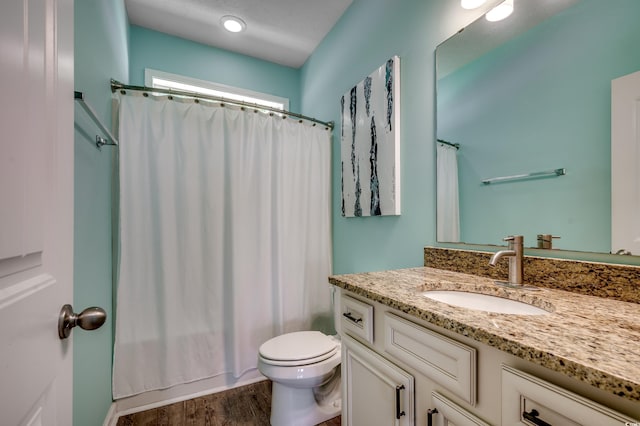 bathroom featuring wood-type flooring, vanity, and toilet