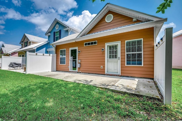 rear view of property featuring a patio and a lawn