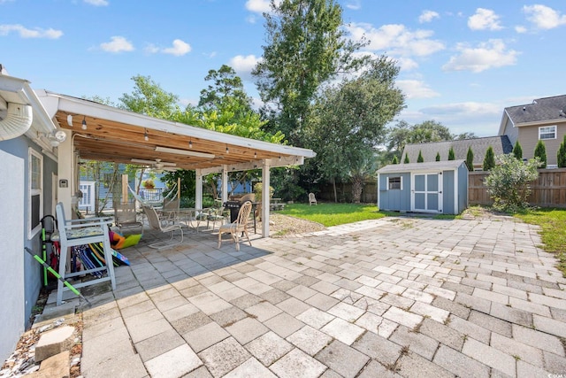 view of patio with ceiling fan and a storage unit