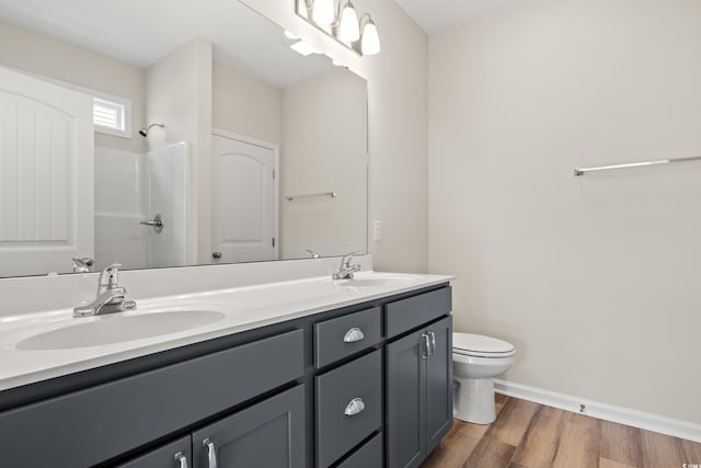 bathroom with a shower, vanity, hardwood / wood-style flooring, and toilet