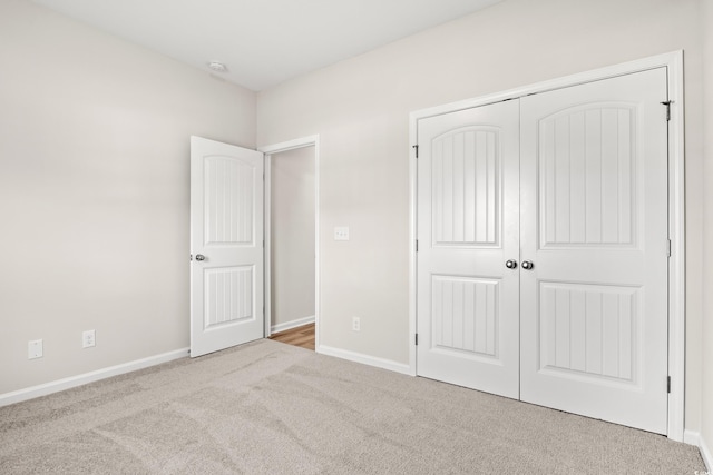 unfurnished bedroom featuring a closet and light colored carpet