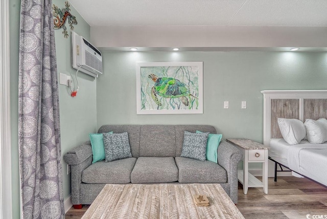 living room featuring hardwood / wood-style flooring and a wall unit AC