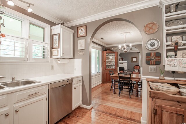 kitchen featuring dishwasher, light wood-type flooring, ornamental molding, and a textured ceiling