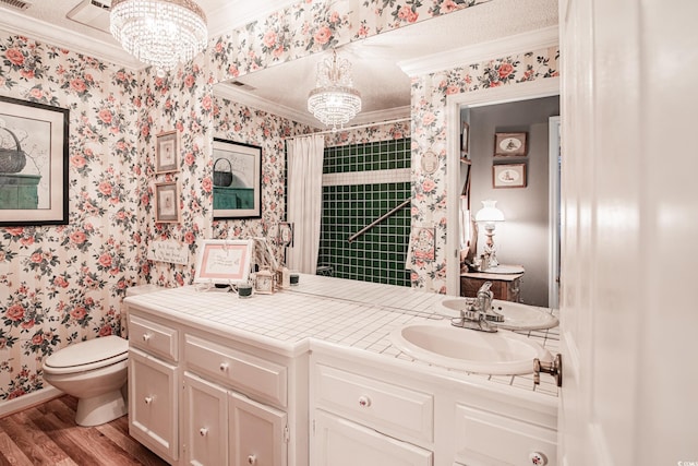 bathroom with crown molding, toilet, hardwood / wood-style floors, a notable chandelier, and vanity