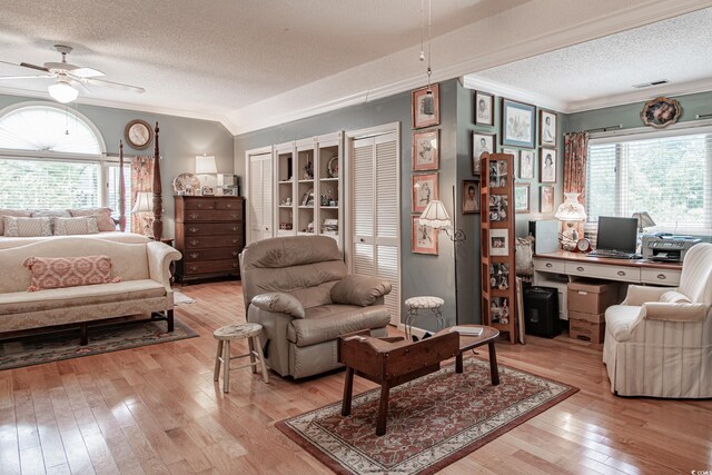 interior space featuring ceiling fan, light hardwood / wood-style flooring, a textured ceiling, and a healthy amount of sunlight