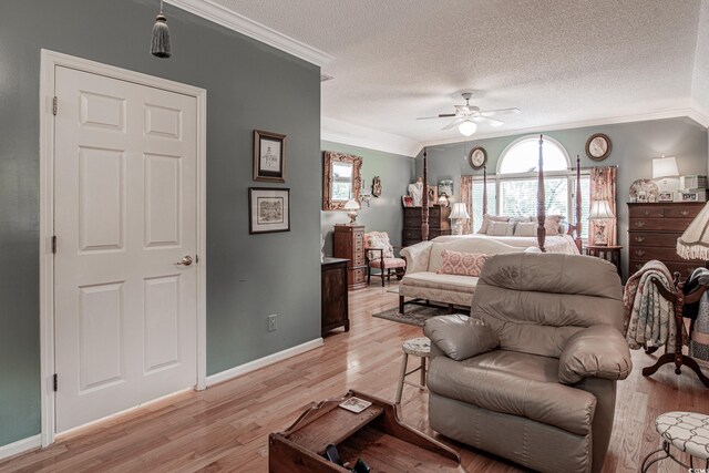 bedroom featuring ceiling fan, light wood-type flooring, ornamental molding, and a textured ceiling