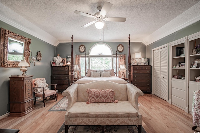 bedroom with a textured ceiling, ceiling fan, ornamental molding, a closet, and light hardwood / wood-style flooring