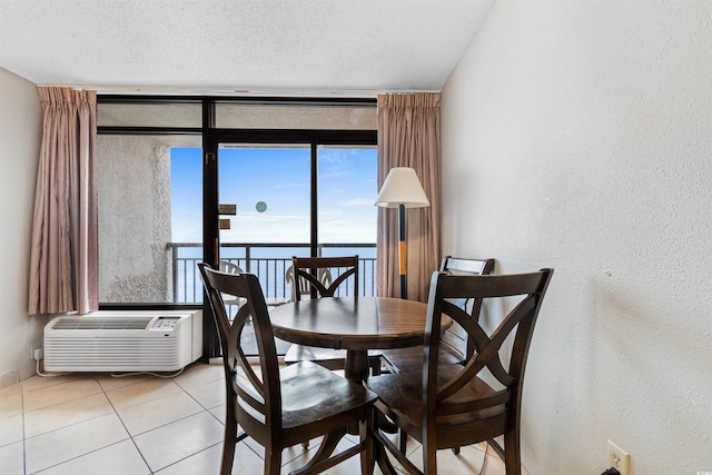 tiled dining space featuring a textured ceiling and a wall unit AC