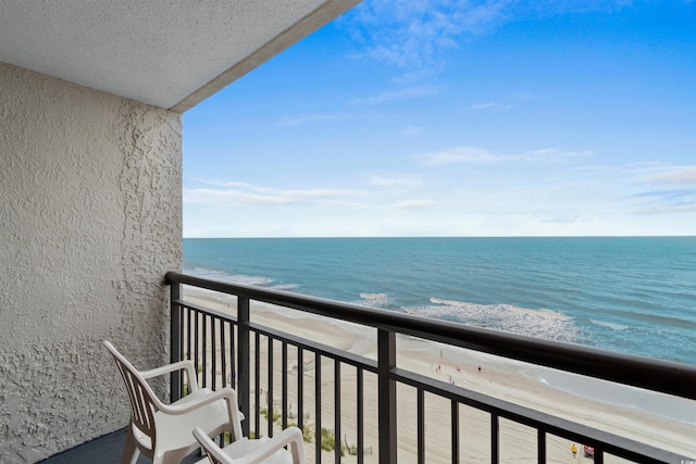 balcony featuring a view of the beach and a water view