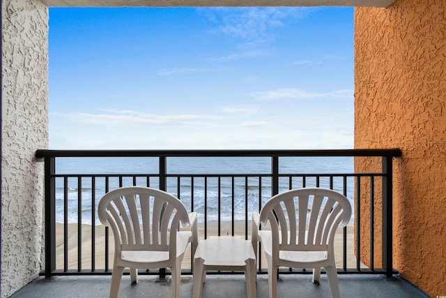 balcony featuring a beach view and a water view