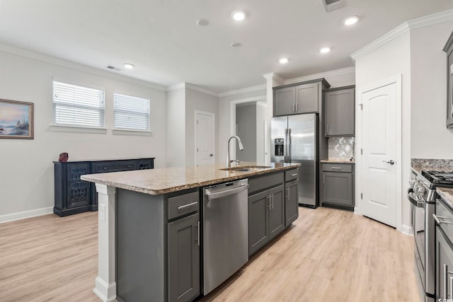 kitchen featuring light hardwood / wood-style flooring, a kitchen island with sink, gray cabinetry, sink, and stainless steel appliances