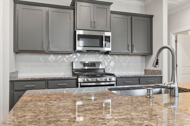 kitchen featuring backsplash, appliances with stainless steel finishes, light stone counters, and crown molding