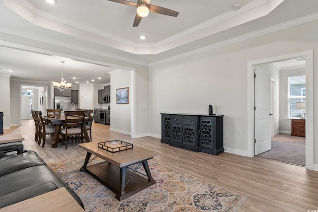 living room featuring a raised ceiling and ornamental molding